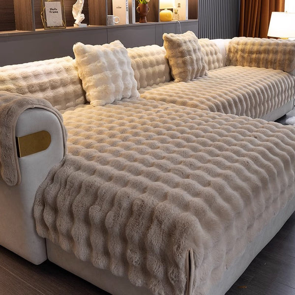 Luxe beige pluchen bankhoes met gewatteerd patroon, perfect voor woonkamerinrichting. Zachte, comfortabele stof, ideaal voor bescherming en stijl.
