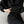 Vrouw in zwarte oversized hoodie en joggingbroek, ontspannen pose op grijze achtergrond. Comfortabele loungewear, modieuze casual kledingstijl.