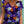 Vrouw draagt kleurrijk bloemen T-shirt met viooltjesprint, casual zomermode, trendy dameskleding, paarse en oranje bloemen, boho-stijl.