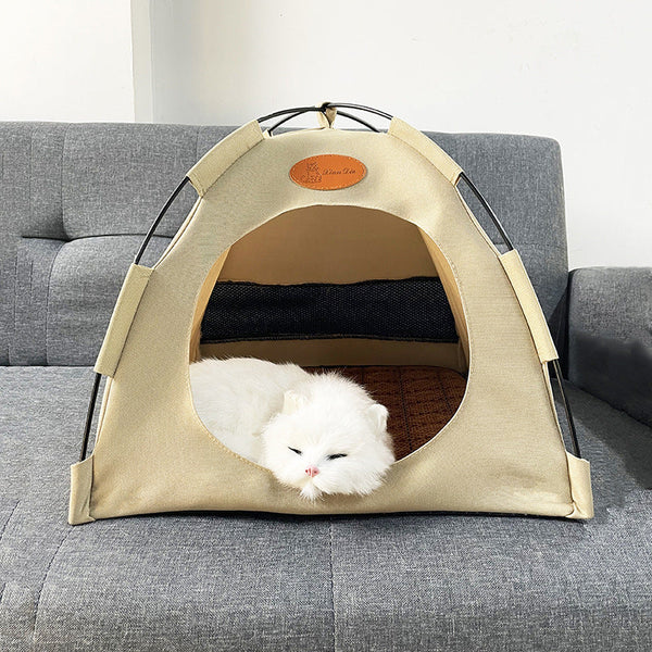 Witte kat slaapt in beige kattenmand op grijze bank. Comfortabele huisdierentent, huisdierbed, kattenhuis, kattenmeubel, huisdieraccessoires.