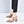 Beige leren dameshakken met blokhak en verstelbare band, gedragen met zwarte broek. Stijlvolle schoenen voor modebewuste vrouwen.