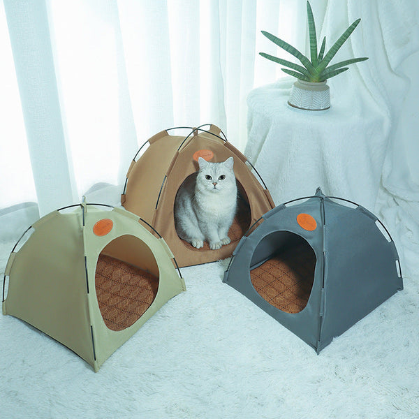 Grijze kat in bruine kattentent, omringd door beige en grijze tenten, naast een groene plant op witte achtergrond. Perfect voor huisdiercomfort.