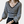 Vrouw in zwart-wit gestreepte trui met V-hals en ballonmouwen, modieuze dameskleding, casual stijl, trendy outfit.