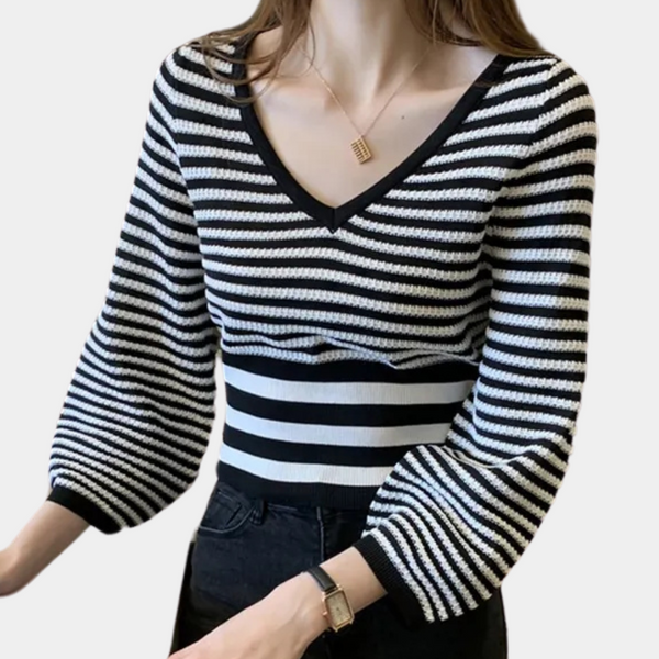 Vrouw in zwart-wit gestreepte trui met V-hals en ballonmouwen, modieuze dameskleding, casual stijl, trendy outfit.