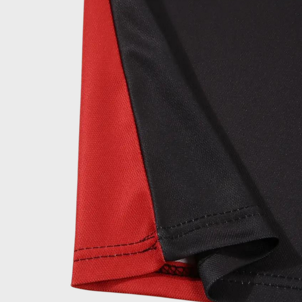 Zwart-rood gestreept herenpoloshirt, close-up van de zoom. Hoogwaardige stof, moderne stijl, perfect voor casual en zakelijke gelegenheden.