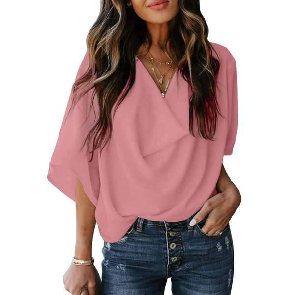 Vrouw in roze blouse met V-hals en driekwart mouwen, gecombineerd met blauwe jeans. Modieuze dameskleding, casual stijl.