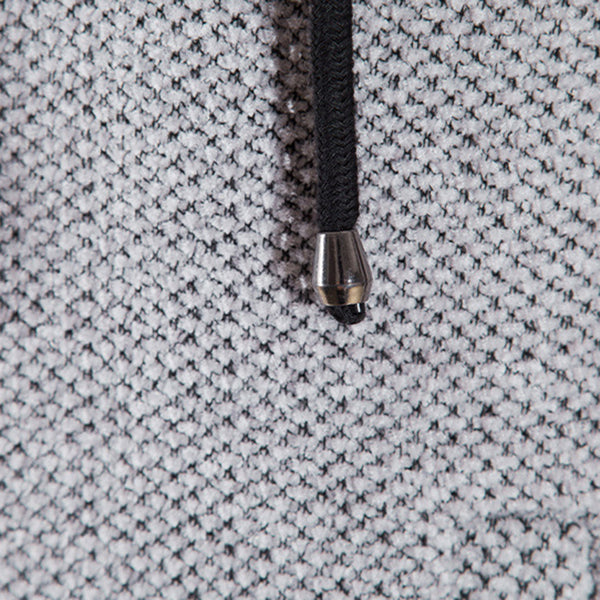 Grijze gebreide stof close-up met zwart trekkoord en metalen uiteinde, textuur detail, modeaccessoire, hoogwaardige kledingmaterialen.