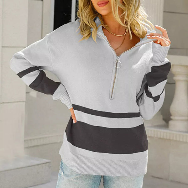 Vrouw in grijze trui met rits en zwarte strepen, casual mode, buiten, trendy dameskleding, herfst-winter outfit, comfortabele stijl.