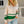 Vrouw draagt beige trui met groene strepen en ritssluiting, casual mode, herfstkleding, trendy dameskleding, buiten, lichte achtergrond.