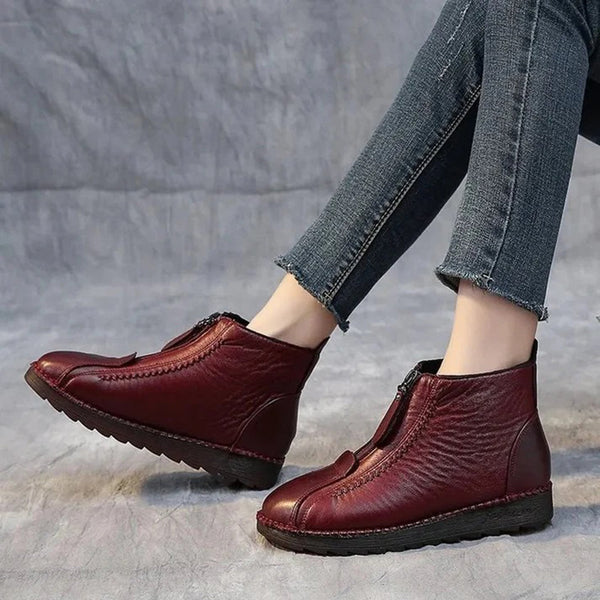 Rode leren enkellaarsjes met ritssluiting, gedragen door model in blauwe jeans. Comfortabele dameslaarzen, casual stijl, ideaal voor dagelijks gebruik.