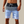 Man in gestreepte blauwe en zwarte zwembroek met trekkoord, strandmode, zomerkleding, herenzwembroek, casual strandoutfit.