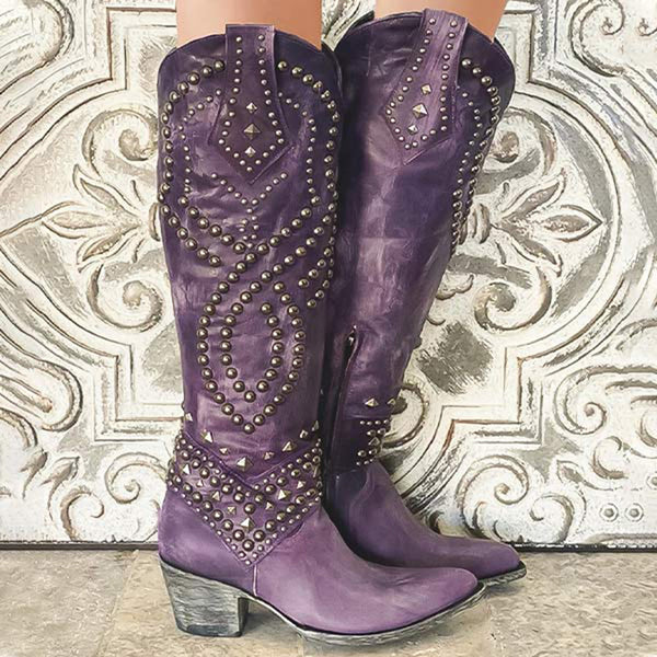 Paarse leren cowboylaarzen met studs, vintage stijl, op decoratieve achtergrond. Perfect voor mode, western laarzen, damesaccessoires.