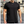 Man in zwarte T-shirt met korte mouwen en zilveren ketting, buiten gefotografeerd. Casual herenkleding, stedelijke achtergrond, mode.