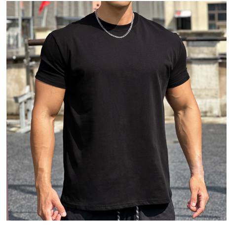 Man in zwarte T-shirt met korte mouwen en zilveren ketting, buiten gefotografeerd. Casual herenkleding, stedelijke achtergrond, mode.