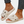 Witte pluche slippers met kerstboom- en sneeuwvlokmotief, gedragen door een persoon met jeans en een stervormige enkelband. Perfect voor wintermode.