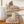 Beige pluche pantoffels met dikke, gewatteerde zolen op houten oppervlak. Comfortabele, warme slippers voor binnengebruik. Trendy en knus design.