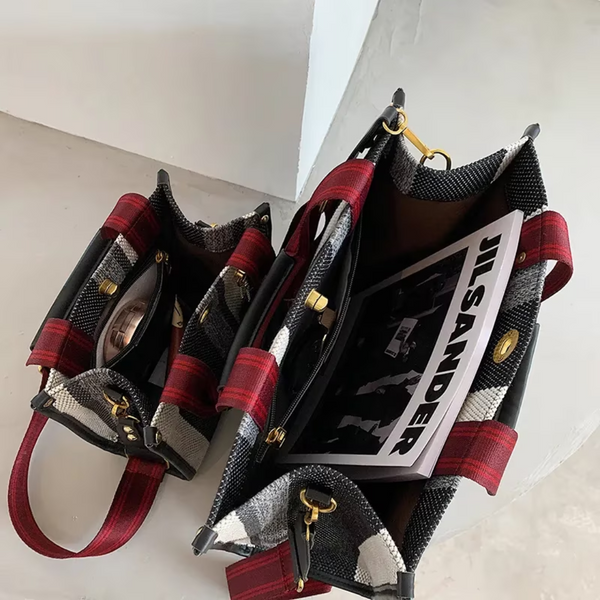 Twee openstaande rood-zwarte geruite tassen met tijdschrift en accessoires op een lichte vloer. Stijlvolle handtassen, modieuze accessoires.