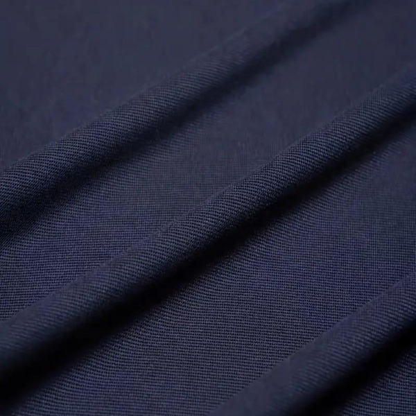 Donkerblauwe piqué stof close-up, ideaal voor heren poloshirts. Hoogwaardige textuur, ademend en duurzaam. Perfect voor casual en zakelijke kleding.