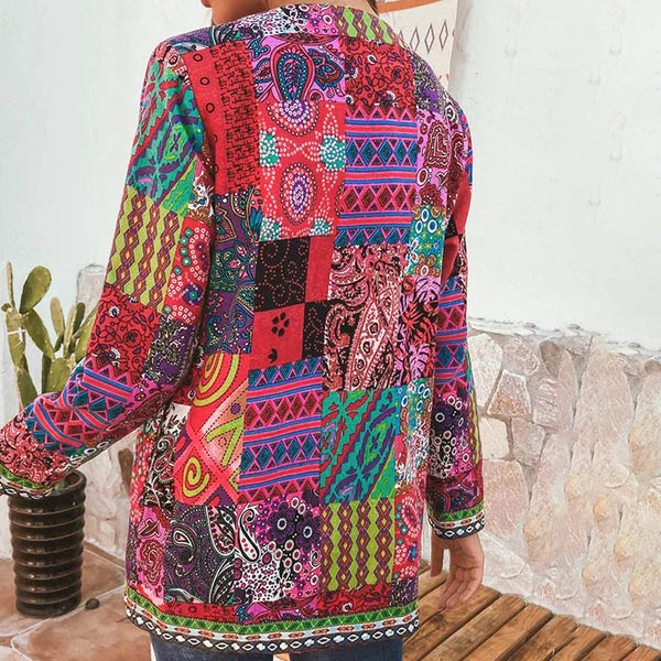 Vrouw in kleurrijke patchwork jas met etnische patronen, staand bij een cactus. Bohemian mode, opvallende kleuren, unieke stijl.