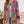 Vrouw draagt kleurrijke boho-chic jas met etnische patronen, ideaal voor modieuze herfstoutfits. Perfecte mix van stijl en comfort.