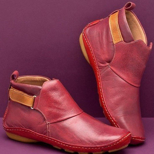 Rode leren enkellaarsjes met bruine zool en klittenbandsluiting, stijlvolle damesmode, comfortabele casual schoenen, herfstcollectie.