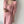 Vrouw in roze gebreide jurk met kabelpatroon en bijpassend vest, versierd met parelketting. Elegante damesmode, herfstkleding, trendy outfit.