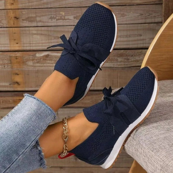 Donkerblauwe dames sneakers met strik, gebreid bovenwerk en witte zool. Comfortabele casual schoenen, perfect voor dagelijks gebruik en modebewuste stijl.
