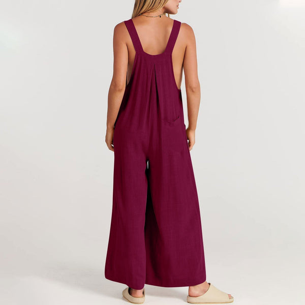 Vrouw in bordeauxrode jumpsuit met wijde pijpen, rugaanzicht. Modieuze dameskleding, casual zomeroutfit, comfortabele pasvorm.