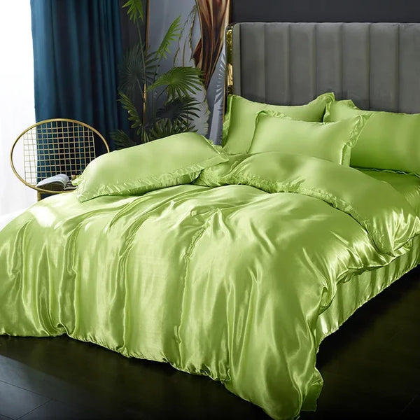 Luxe groene satijnen dekbedovertrek set op een grijs gestoffeerd bed, met kussens en planten op de achtergrond, slaapkamer interieur.