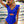 Vrouw in blauwe badpak met ruches, strand op achtergrond. Zomer mode, strandkleding, trendy badmode, zeezicht, zonsondergang.