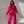 Vrouw in felroze joggingpak met capuchon, poseert tegen een neutrale achtergrond. Modieuze dameskleding, comfortabele loungewear, trendy outfit.