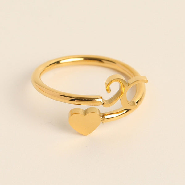 Gouden ring met hart- en cijferontwerp, minimalistisch en elegant, perfect als cadeau of accessoire. Ideaal voor mode- en sieradenliefhebbers.