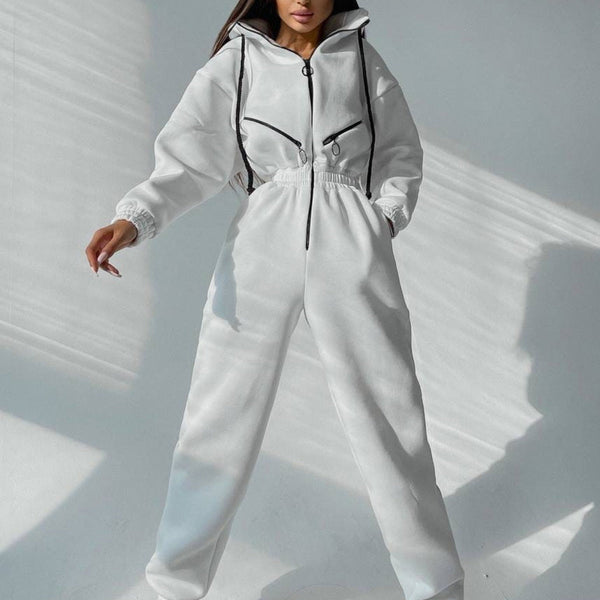 Vrouw in witte sportieve jumpsuit met capuchon en zwarte ritsen, modieuze streetwear, casual outfit, trendy dameskleding, minimalistisch design.