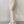 Vrouw in beige flared broek en witte sneakers tegen een grijze achtergrond. Modieuze dameskleding, trendy broeken, casual outfit.