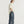 Jongeman in casual outfit met beige pet, oversized T-shirt en wijde jeans, zijaanzicht. Modetrend, streetwear, comfortabele kledingstijl.