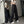 Vrouw in zwarte wijde broek met witte strepen, crop top en pet, poseert voor spiegel. Trendy streetwear mode, casual outfit, moderne stijl.