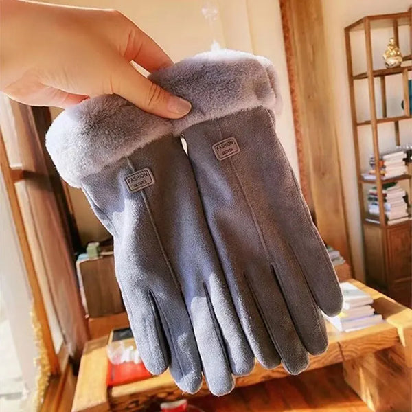Grijze suède handschoenen met zachte voering, vastgehouden in een zonnige kamer. Winteraccessoires, warme handschoenen, modieuze winterkleding.