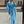 Vrouw in stijlvolle blauwe trenchcoat, witte tas en hakken op stedelijke achtergrond. Elegante mode, herfstkleding, straatstijl.