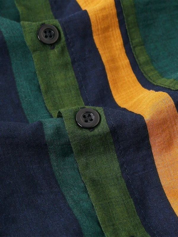 Gestreepte katoenen stof met groene, blauwe en gele banen en zwarte knopen. Ideaal voor modieuze kleding en interieurdecoratie.