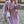 Vrouw in lila oversized jas met witte handtas, modieuze straatstijl, herfstmode, trendy dameskleding, stedelijke achtergrond.