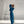 Vrouw in blauwe joggingpak en sneakers in minimalistisch interieur, moderne sportkleding, comfortabele loungewear, casual mode, fitnesskleding.