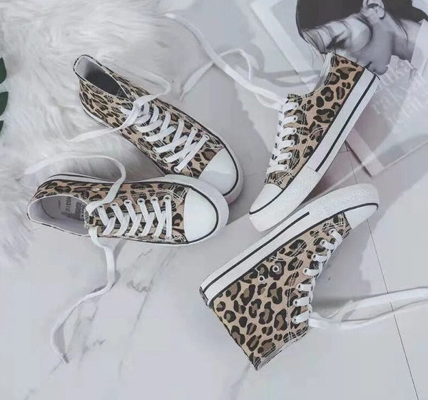 Luipaardprint sneakers met witte zolen en veters op marmeren achtergrond, trendy modeaccessoire, casual dames schoenen.