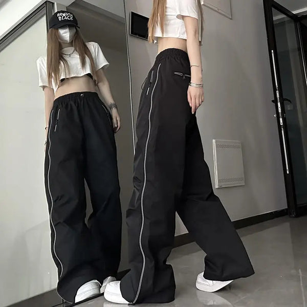 Vrouw in spiegelbeeld draagt zwarte wijde broek en wit crop top, met pet en sneakers. Trendy streetwear mode, casual outfit, urban stijl.