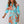 Vrouw in blauwe jurk met oranje bloemenprint, lange mouwen en V-hals. Modieuze dameskleding, elegant ontwerp, geschikt voor lente en zomer.