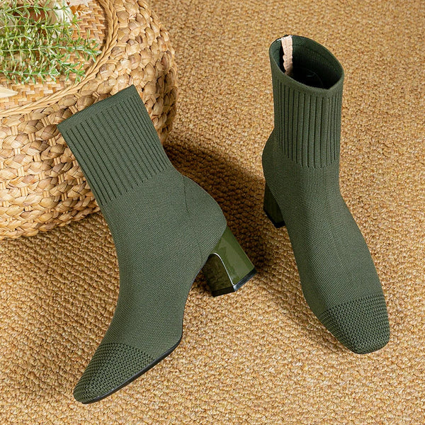 Groene gebreide enkellaarsjes met blokhak op geweven tapijt, stijlvolle damesmode, comfortabele herfst- en winterlaarzen, trendy schoenen.