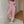Vrouw in roze joggingpak leunt tegen muur, draagt witte sneakers. Comfortabele loungewear, casual mode, trendy dameskleding.