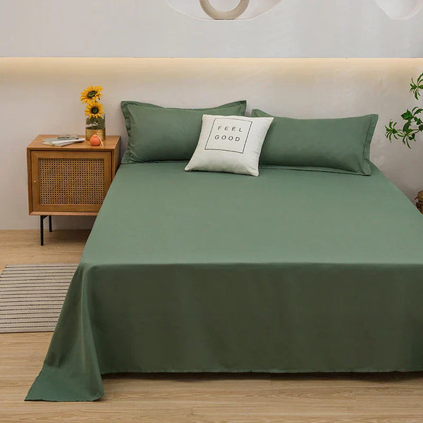 Groen dekbedovertrek op tweepersoonsbed met kussen "Feel Good", houten nachtkastje met zonnebloemen, moderne slaapkamerinrichting.