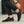 Zwarte sneakers met bruine zool, gedragen door persoon in zwarte broek. Stijlvolle casual schoenen voor dagelijks gebruik. Comfortabele en modieuze keuze.