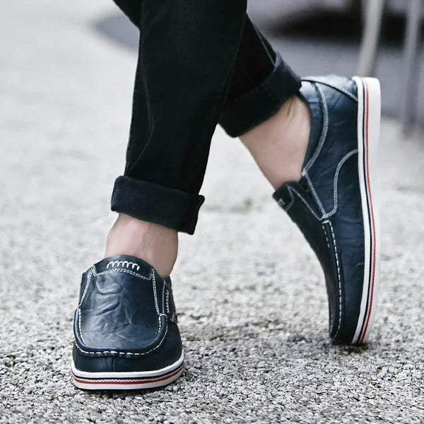 Donkerblauwe leren loafers voor heren, casual stijl, met witte en rode zoolaccenten. Comfortabele schoenen voor dagelijks gebruik.