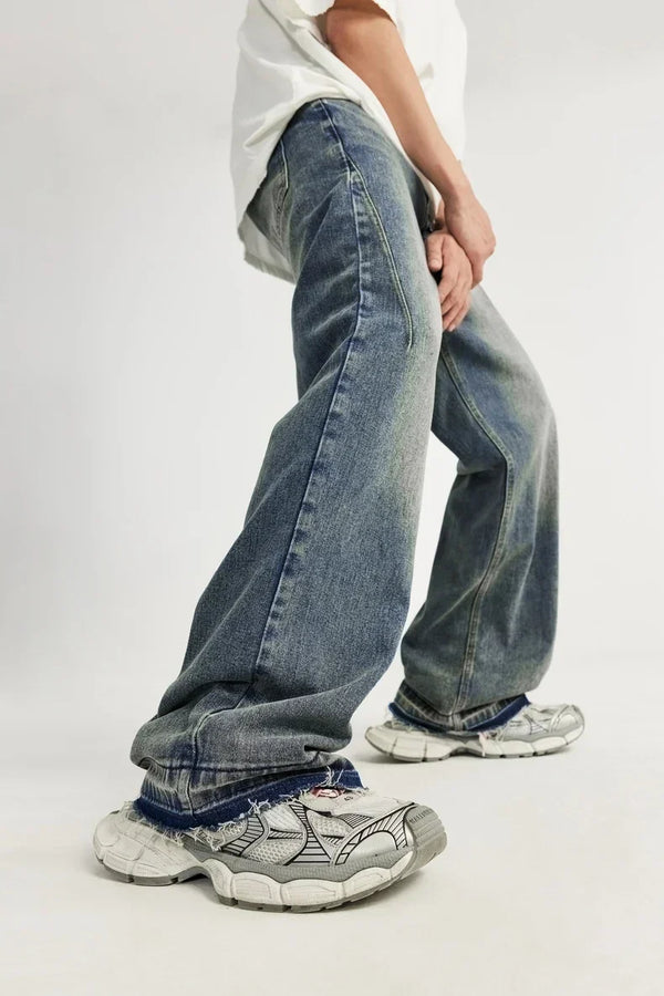 Wijd uitlopende jeans en witte sneakers, casual mode, streetwear stijl, mannelijke model poseert, trendy denim, comfortabele schoenen, urban outfit.